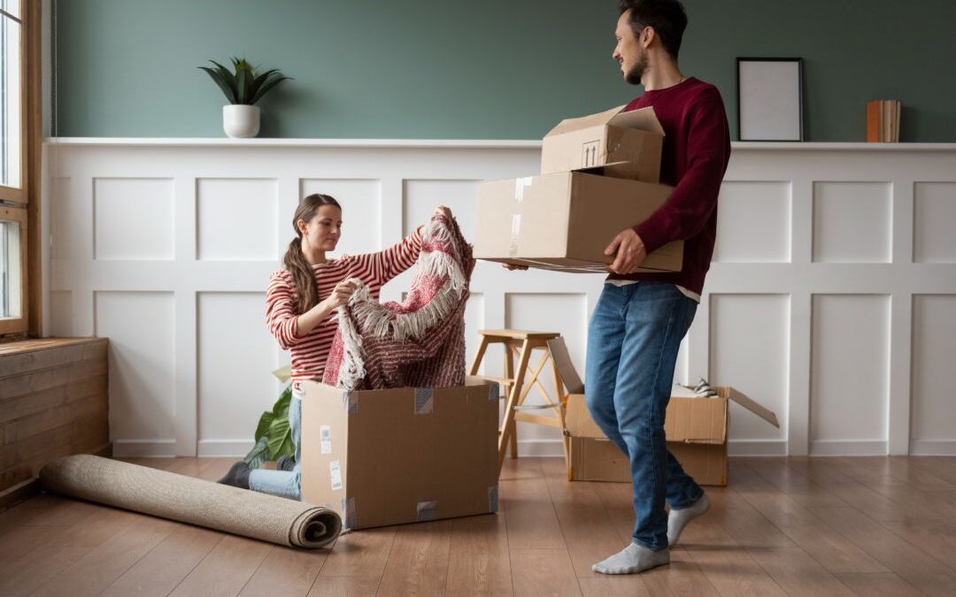 Young couple moving into a new home, carrying boxes