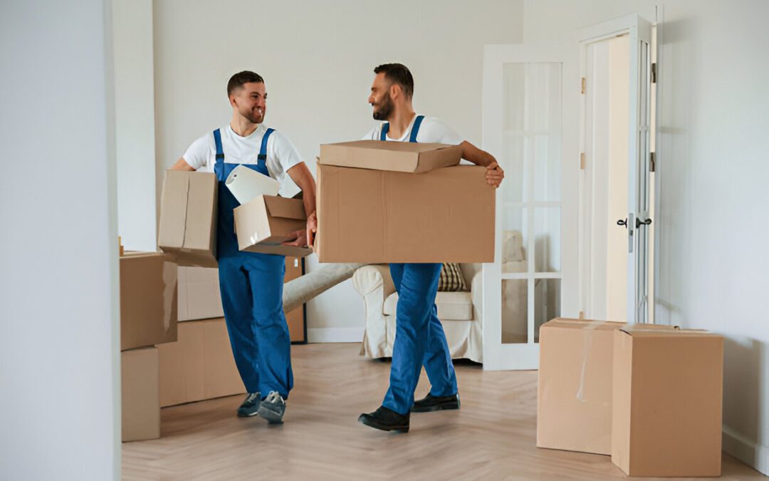 Boxes in hands. Two moving service employees in a room